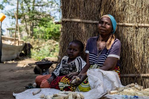 Terezinha sits with her grandson as she prepares her only harvest from her farm