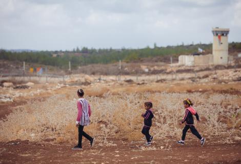 Ameera, 11, and her sisters walk along their farmland in the West Bank