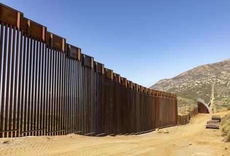 High border wall separating the US and Mexico.  