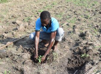 Okech practices his farming skills in Uganda