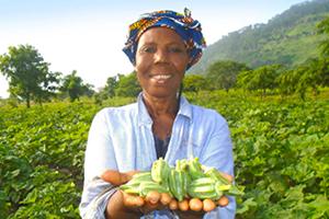 A woman farmer holding some produce from her farm