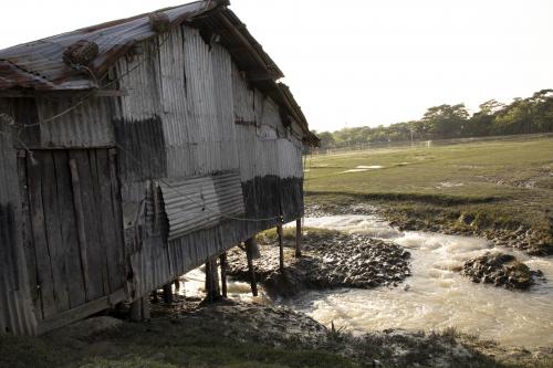 Home standing on an embankment with the sea on one side and flooded fields on the other, the water flows beneath it on a daily basis.