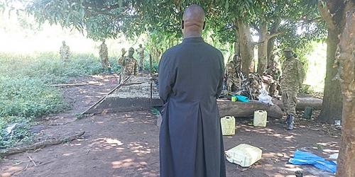 A Catholic priest confronts soldiers in the camp