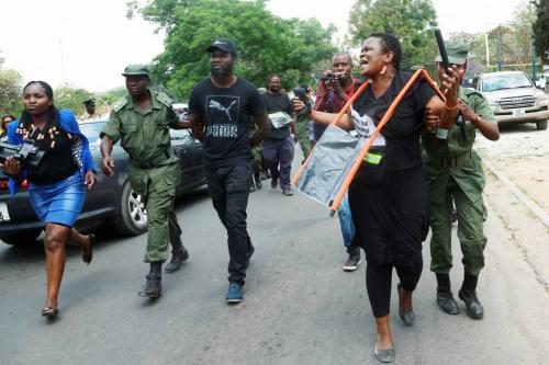 The photo shows Laura and Pilato being dragged away by police