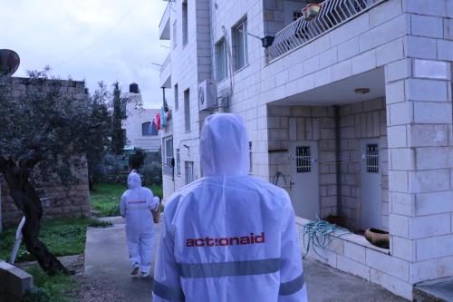 People in protective equipment delivering aid packages to houses