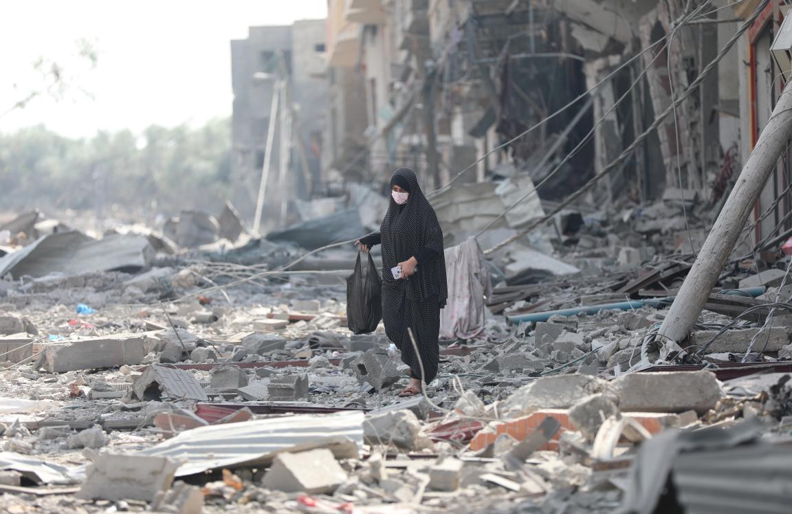 A woman resident of Gaza City searches the rubble for belongings in the aftermath of bombing by the Israeli army.