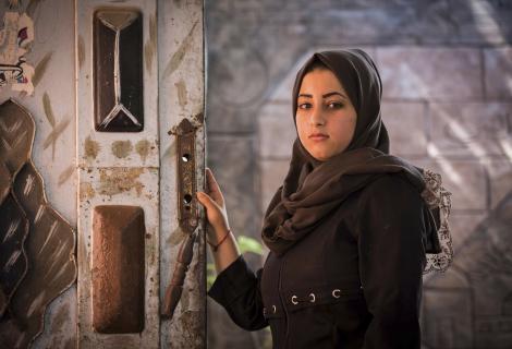 Dalia, a 18-year-old girl, standing in her family house in Gaza, where her and the rest of the family almost got killed by a fire from their candles. The electricity supply in Gaza is sporadic and often lasts between four and six hours a day.