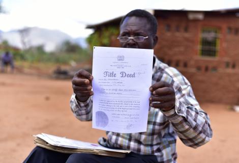 James Mzungu shows a copy of the Title Deed acquired by Mbulia Group Ranch in 2006, more than 20 year after he had been living there. 