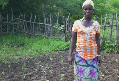Fatou Keita, 32, is a farmer and manages her household in Bakho, Senegal. She stands in smallholding, surrounded by green shoots
