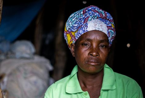 Luisa Mungono sits inside her makeshift house that she spends with her husband and nine children