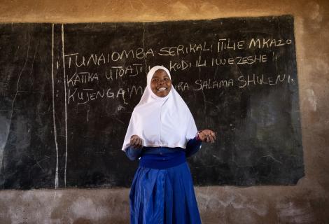Photo of a female school student in front of a chalk board