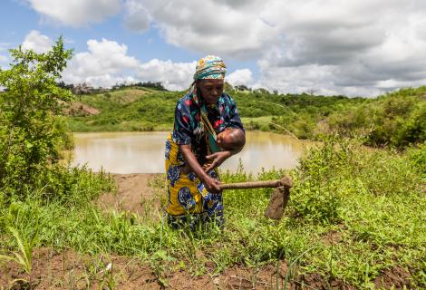 A woman farming with her baby in her arms