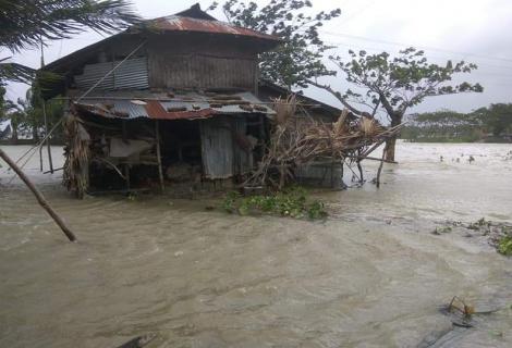 Devastation caused by cyclone Amphan, a flooded house and fallen trees