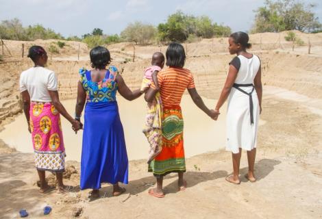 Four women stand together looking into the distance