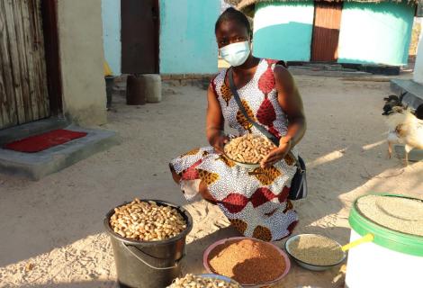 Mavis, a young smallholder farmer from Zimbabwe sits surrounded by her produce 