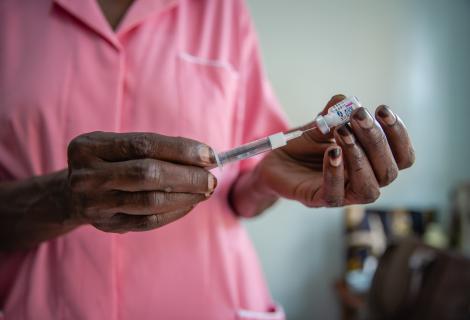 A nurse prepares treatment for a patient in Uganda.