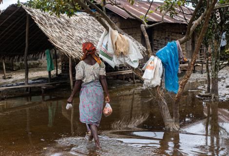 Women walks through her flooded village in the Niger Delta.