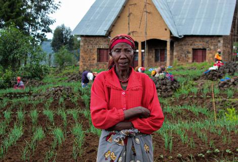 Asteria stands in front of her crops, Rwanda.