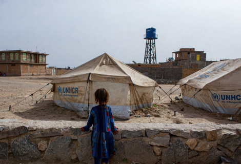 A little girl looks out across an IDP camp in Afghanistan