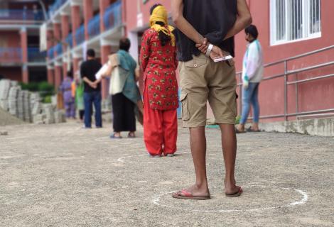 Residents of Kathmandu wait, socially distanced, at a food distribution, April 2020