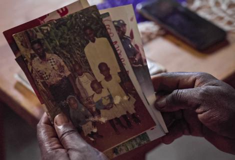 Immaculee looks through photographs of her deceased family 