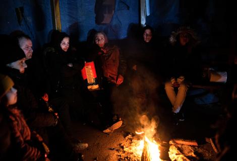 Survivors gather around open flames to keep warm in Hatay, Turkey