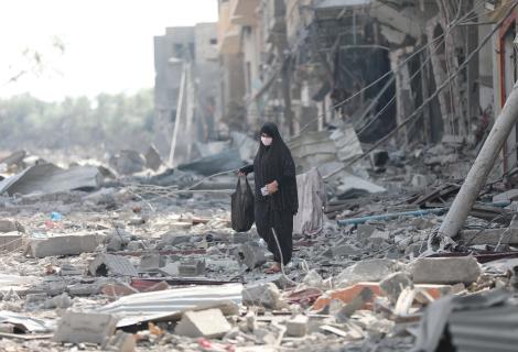 A woman resident of Gaza City searches the rubble for belongings in the aftermath of bombing by the Israeli army.