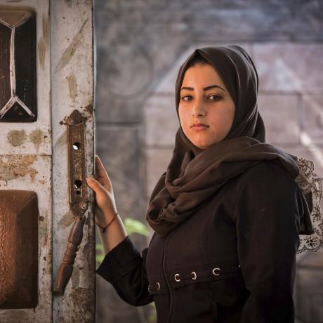 Dalia, a 18-year-old girl, standing in her family house in Gaza, where her and the rest of the family almost got killed by a fire from their candles. The electricity supply in Gaza is sporadic and often lasts between four and six hours a day.