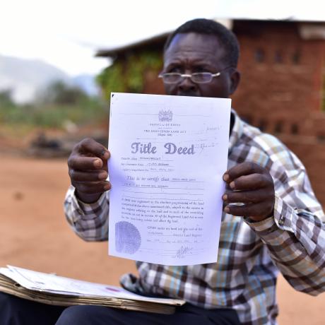 James Mzungu shows a copy of the Title Deed acquired by Mbulia Group Ranch in 2006, more than 20 year after he had been living there. 