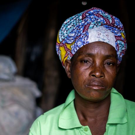 Luisa Mungono sits inside her makeshift house that she spends with her husband and nine children
