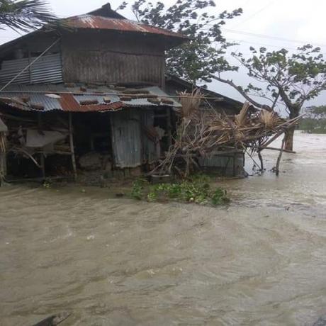 Devastation caused by cyclone Amphan, a flooded house and fallen trees