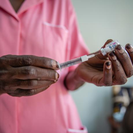A nurse prepares treatment for a patient in Uganda.