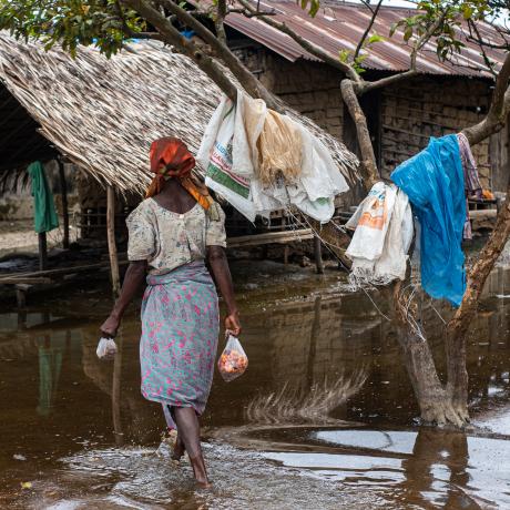Women walks through her flooded village in the Niger Delta.