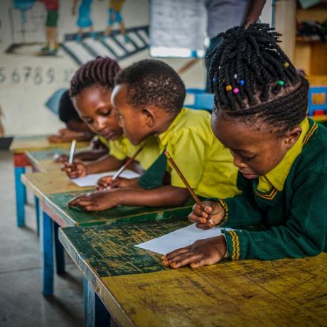 Children writing at school desks 