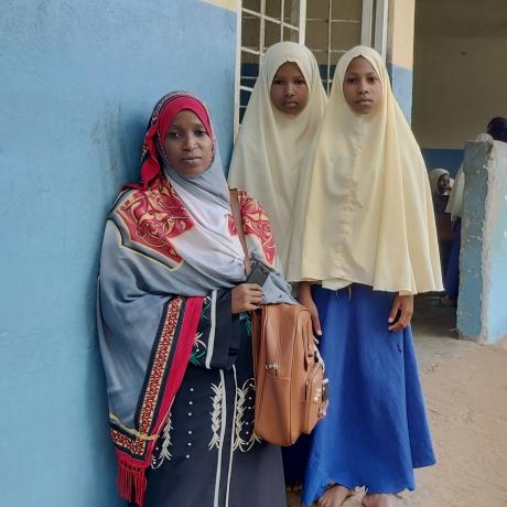 Students stand with their teacher outside a school in North Pemba, Tanzania