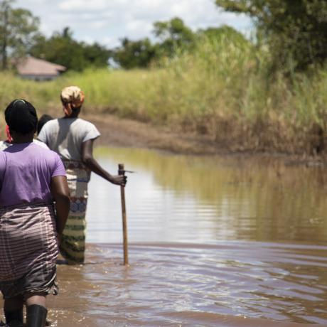 Women walking along a flooded path in Buzi, Mozambique