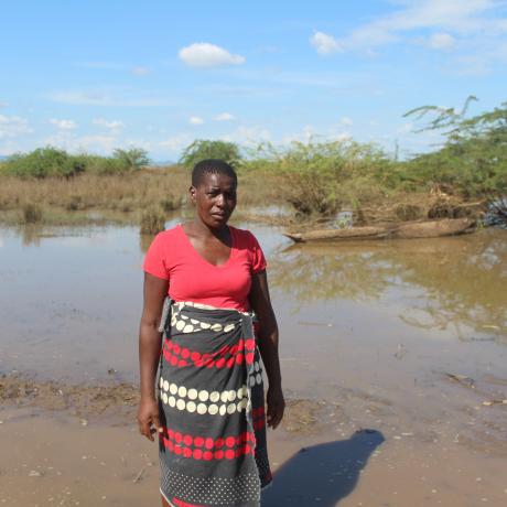 Esnert Thaison, 45, stands in front of her submerged crops after flooding caused by Tropical Storm Ana in Malawi.