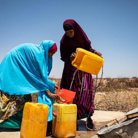 Two women pour water into containers, Somaliland