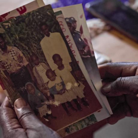 Immaculee looks through photographs of her deceased family 
