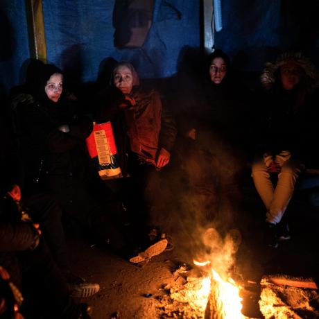 Survivors gather around open flames to keep warm in Hatay, Turkey