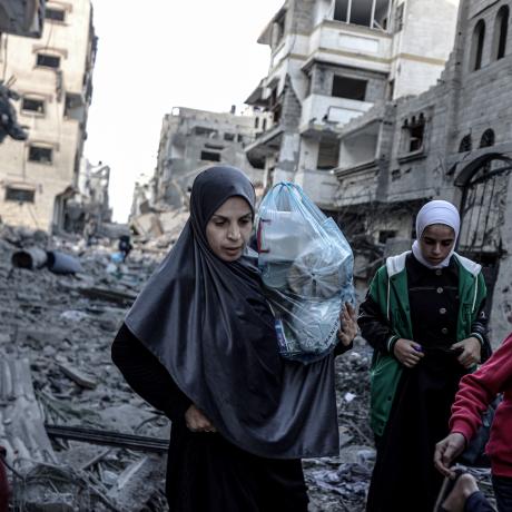 Palestinian women and children carrying belongings flee to safer areas following Israeli bombardments on southern part of Gaza City,