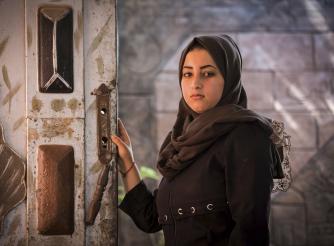 Dalia, a 18-year-old girl, standing in her family house in Gaza, where her and the rest of the family almost got killed by a fire from their candles. The electricity supply in Gaza is sporadic and often lasts between four and six hours a day.