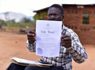 James Mzungu shows a copy of the Title Deed acquired by Mbulia Group Ranch in 2006, more than 20 year after he had been living there. 