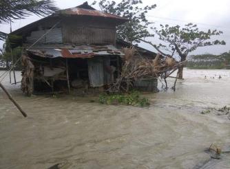 Devastation caused by cyclone Amphan, a flooded house and fallen trees