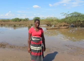 Esnert Thaison, 45, stands in front of her submerged crops after flooding caused by Tropical Storm Ana in Malawi.