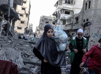 Palestinian women and children carrying belongings flee to safer areas following Israeli bombardments on southern part of Gaza City