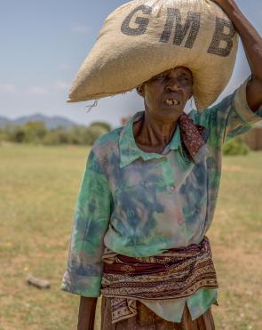 Women walk home after receiving food assistance packs at Chitenderano distribution point in Nyazura