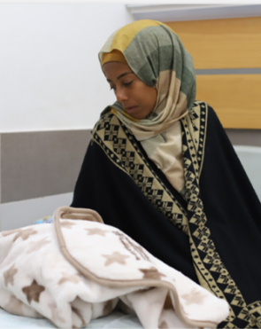 Umm Fulan, a new mother who has just given birth at Al-Awda Hospital. 