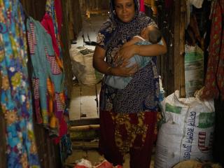 Shahanaz with baby Alifa, walking through the corridors of their housing community.