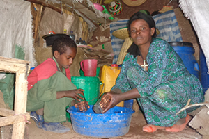 A woman and child cooking in a shack